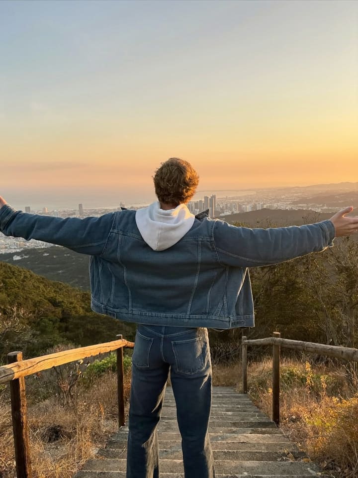 Top step, arms wide, face the skyline at Griffith Observatory